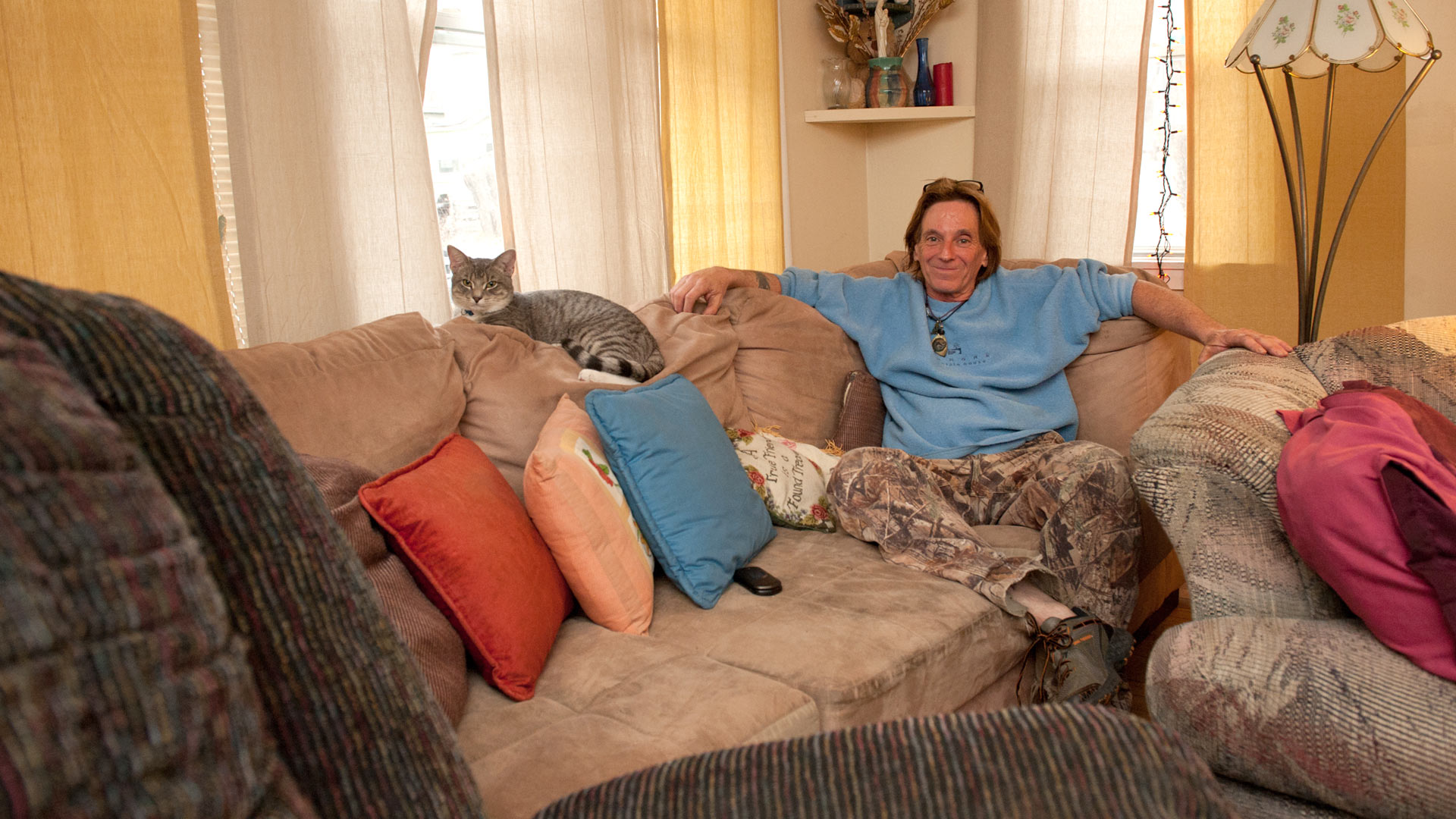 Man sitting on a couch with a cat