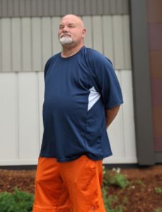 Man standing in front of a building with the words "Juniper House" on it