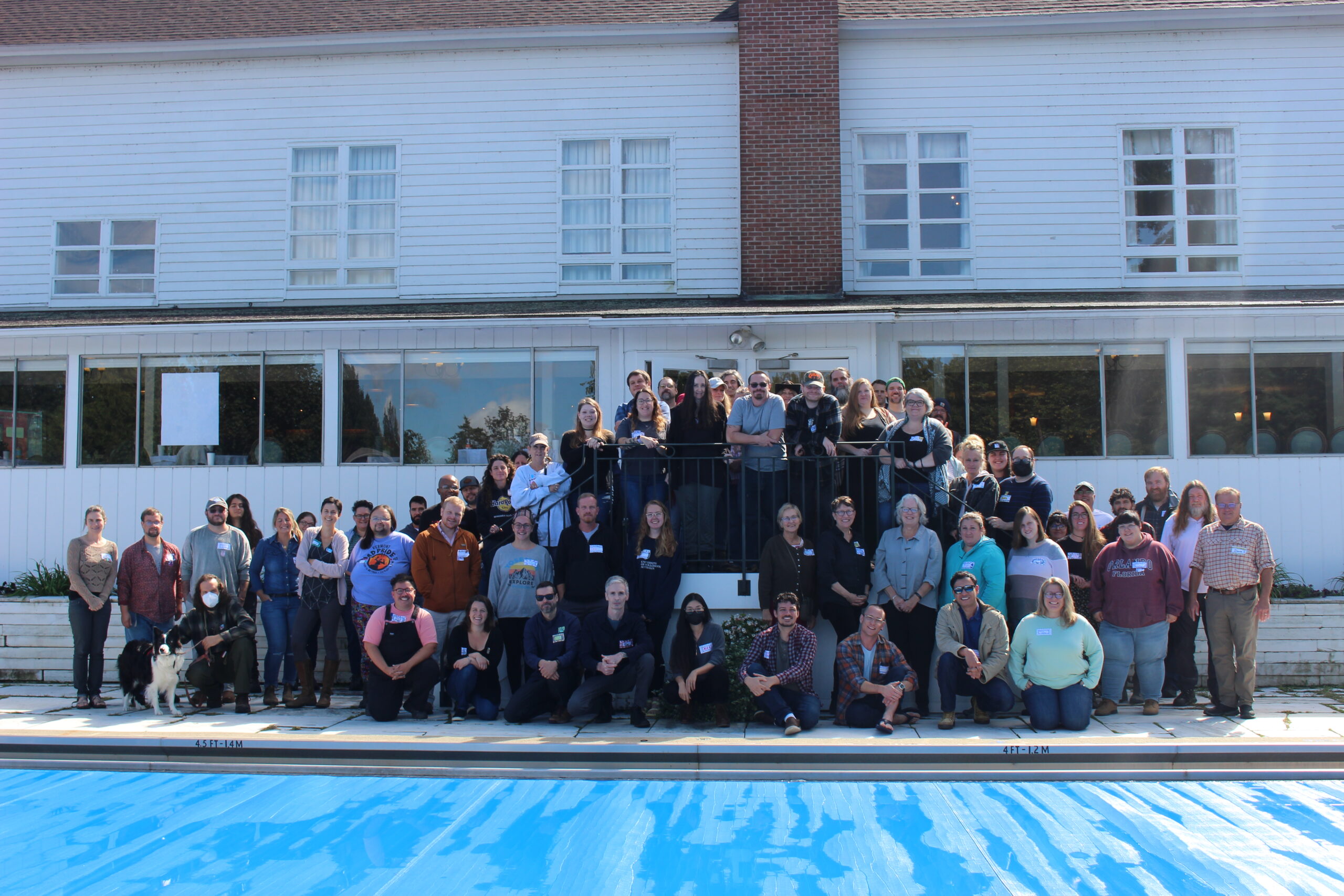 A group of people standing in front of a pool.