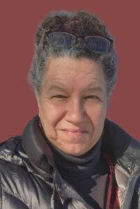 Selfie of a woman behind a red background.